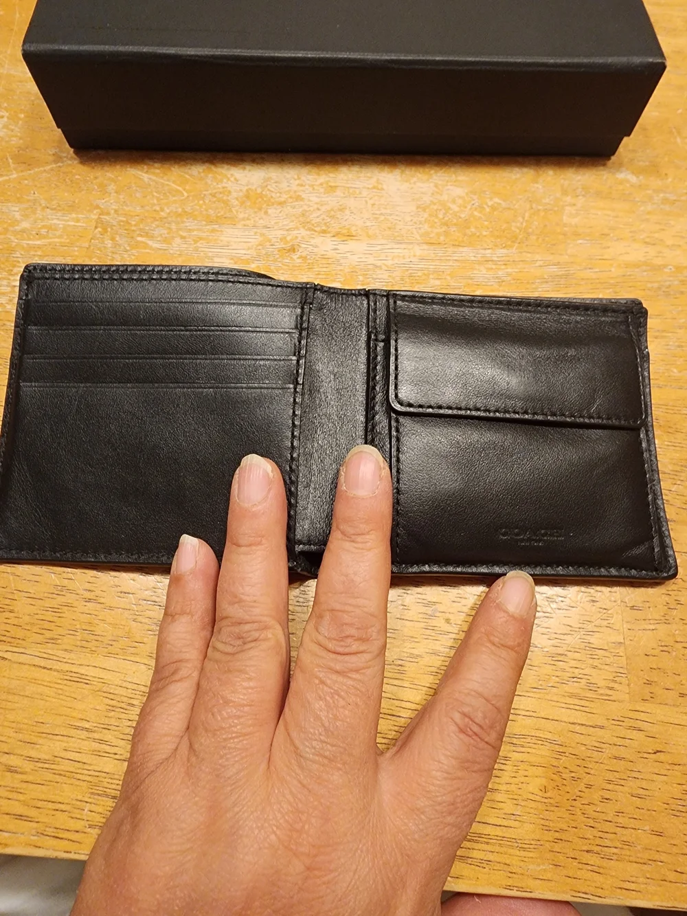 black Coach 3-in-1 wallet featuring the brand's iconic debossed signature pebble